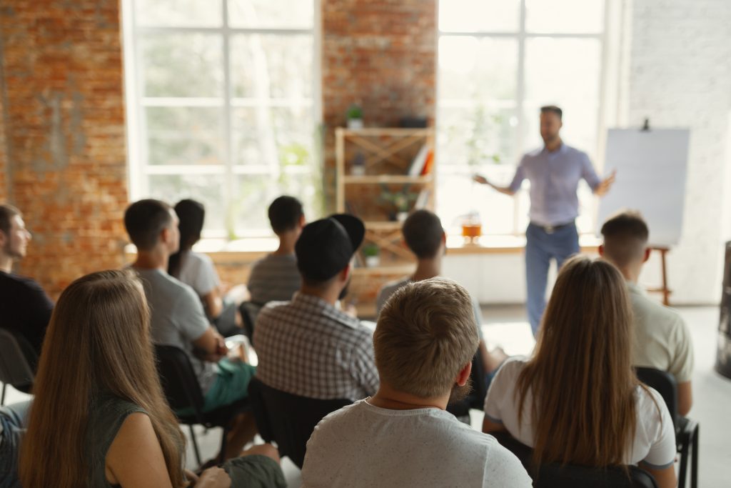 male speaker giving presentation in hall at university workshop